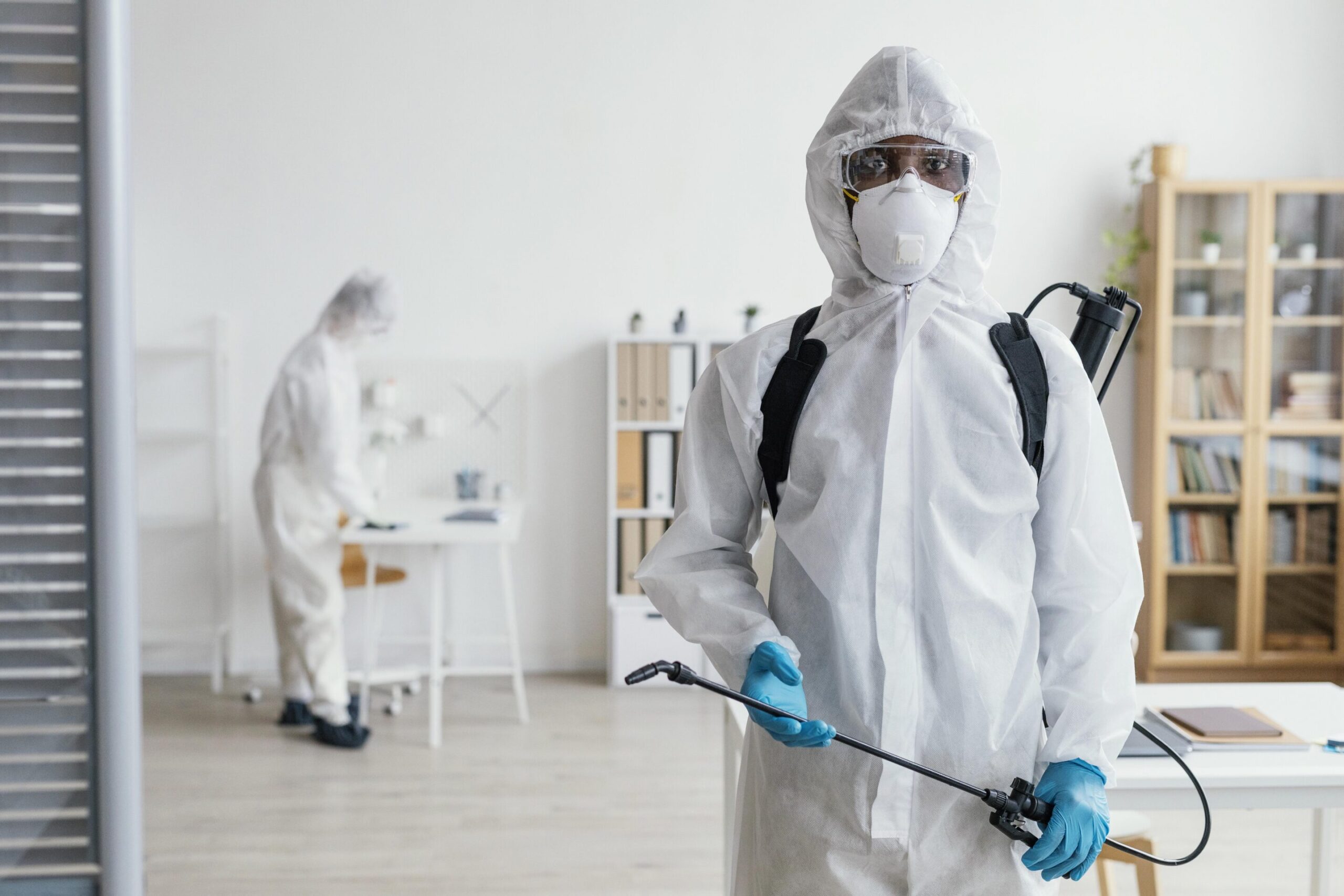 Équipe en combinaison désinfectant une zone contaminée